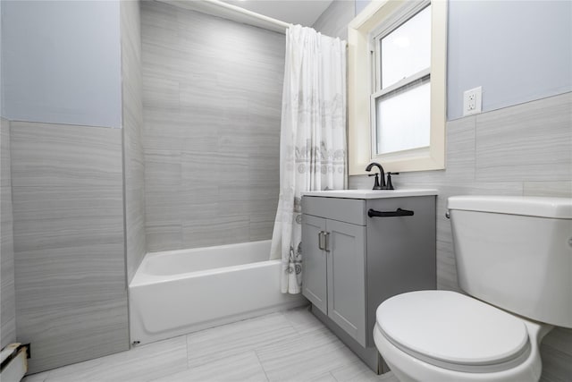 full bathroom featuring shower / tub combo with curtain, toilet, tile walls, baseboard heating, and vanity