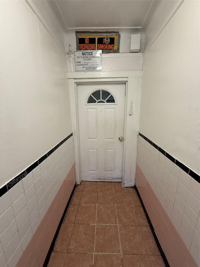 entryway with tile walls and dark tile patterned flooring