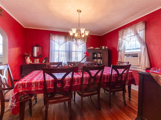 dining room with crown molding, a chandelier, hardwood / wood-style floors, and a textured ceiling