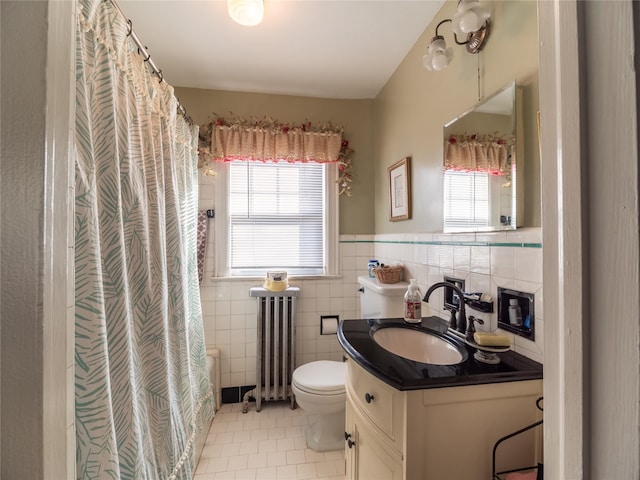 bathroom featuring tile walls, radiator, a wealth of natural light, and tile patterned floors