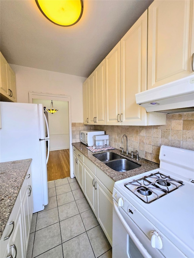 kitchen featuring sink, white appliances, light tile patterned flooring, and backsplash