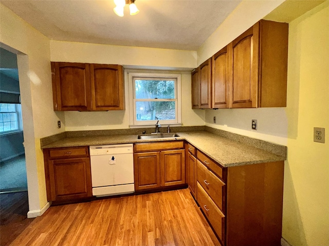 kitchen with dishwasher, sink, and light hardwood / wood-style flooring