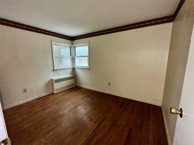 spare room with ornamental molding, radiator, dark wood-type flooring, and a textured ceiling