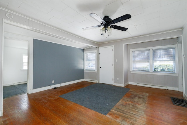 entryway featuring a baseboard radiator, dark wood-type flooring, a wealth of natural light, and crown molding