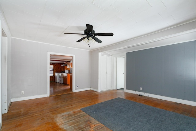 empty room featuring dark wood-type flooring, ceiling fan, and crown molding