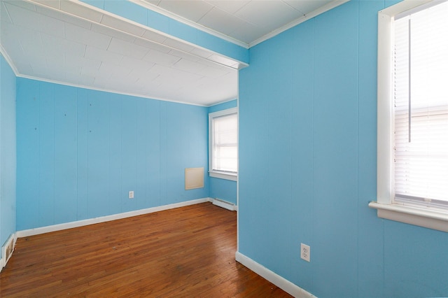 empty room with crown molding and dark hardwood / wood-style flooring