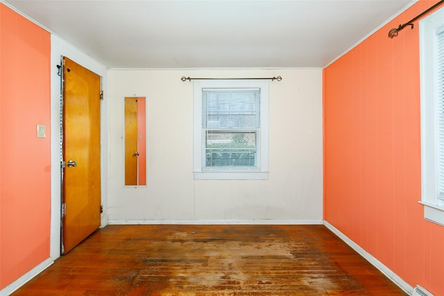 spare room with dark wood-type flooring and a baseboard radiator