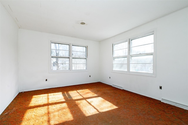 carpeted spare room featuring a baseboard radiator