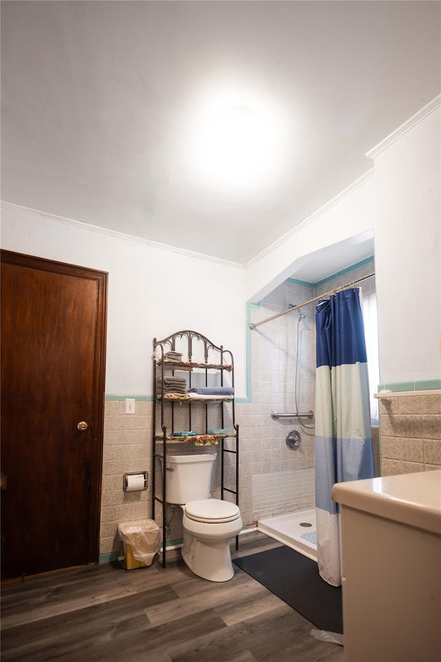 bathroom with tile walls, hardwood / wood-style floors, toilet, and a shower with shower curtain