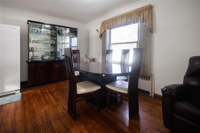 dining room with crown molding and dark hardwood / wood-style floors