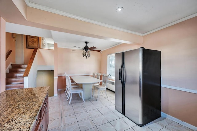 kitchen featuring stainless steel refrigerator with ice dispenser, light tile patterned flooring, crown molding, light stone counters, and radiator heating unit