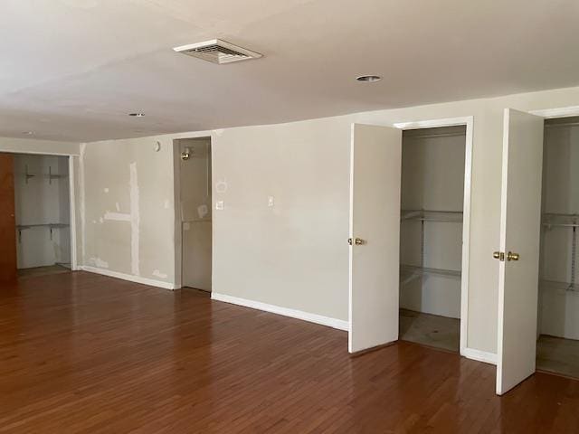 unfurnished room with dark wood-type flooring