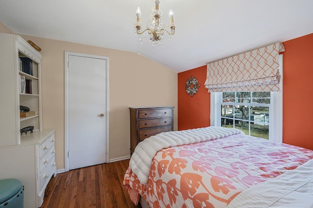 bedroom featuring dark wood-type flooring, lofted ceiling, and a chandelier