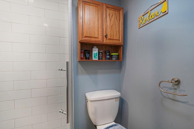 bathroom featuring a tile shower and toilet