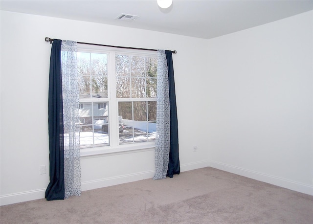 spare room featuring light carpet and a wealth of natural light