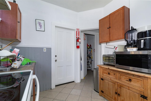 kitchen with light tile patterned floors and white range with electric cooktop