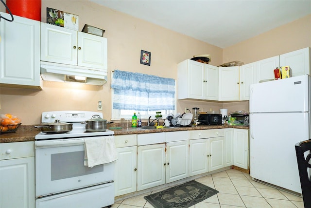 kitchen with sink, light tile patterned floors, white cabinets, and white appliances