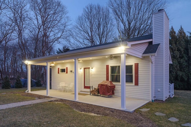 outdoor structure at dusk featuring a yard