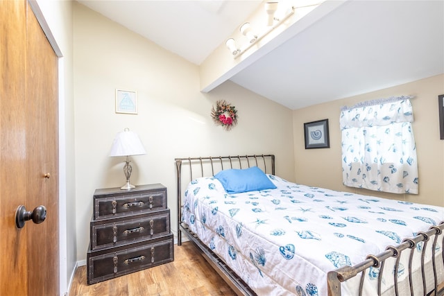 bedroom with beamed ceiling, hardwood / wood-style floors, and a closet