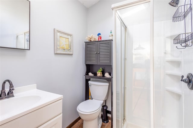 bathroom featuring vanity, toilet, and a shower with shower door