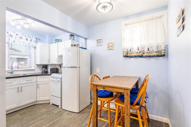 kitchen featuring white cabinetry, sink, hardwood / wood-style floors, and white appliances