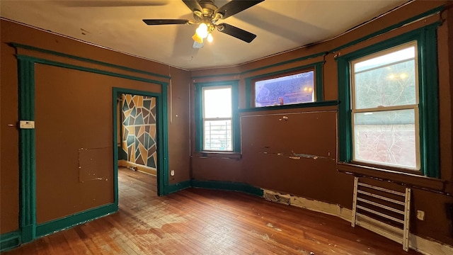 empty room with hardwood / wood-style floors and ceiling fan