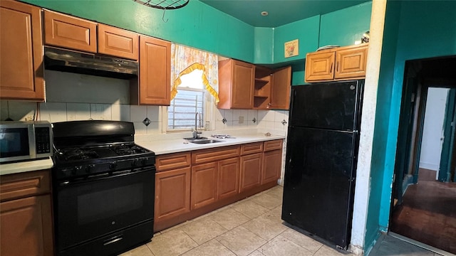 kitchen featuring sink, light tile patterned floors, backsplash, and black appliances