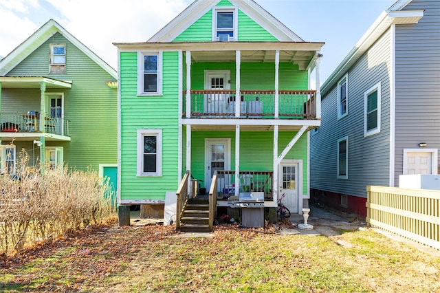 rear view of property with a balcony and a porch