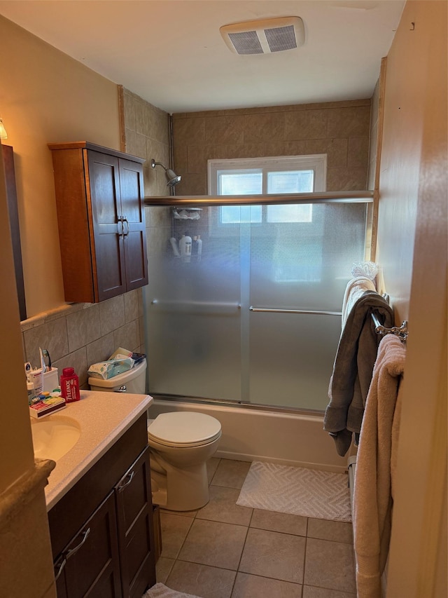 full bathroom with enclosed tub / shower combo, tile patterned flooring, backsplash, vanity, and toilet