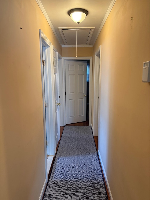 hallway with dark colored carpet and ornamental molding