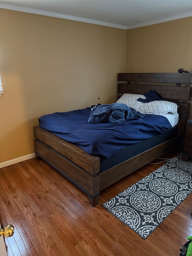 bedroom featuring wood-type flooring and ornamental molding