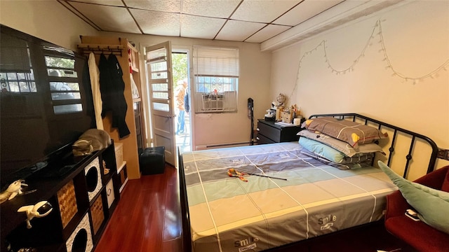 bedroom featuring cooling unit, a paneled ceiling, dark hardwood / wood-style floors, and a baseboard heating unit