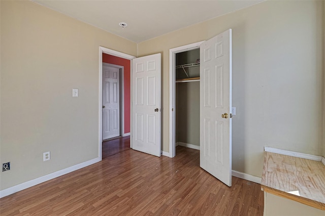 unfurnished bedroom with hardwood / wood-style floors and a closet