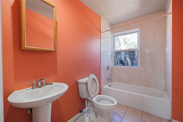 bathroom featuring tile patterned flooring, tiled shower / bath, and toilet