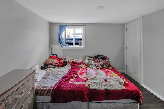 bedroom with dark hardwood / wood-style flooring