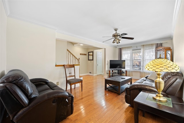 living room with crown molding, ceiling fan, and light wood-type flooring