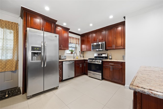 kitchen featuring sink, light tile patterned floors, ornamental molding, and appliances with stainless steel finishes