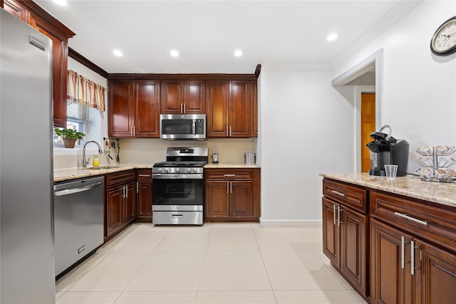 kitchen featuring sink, crown molding, stainless steel appliances, and light stone countertops