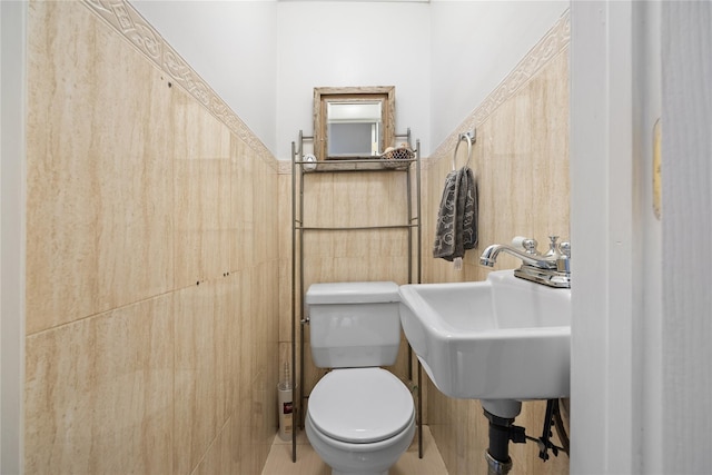 bathroom featuring tile walls, sink, and toilet