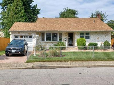 ranch-style house featuring a garage and a front lawn