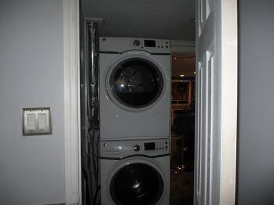 washroom featuring stacked washing maching and dryer