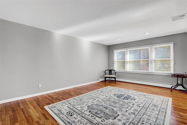 sitting room with hardwood / wood-style floors and a baseboard radiator