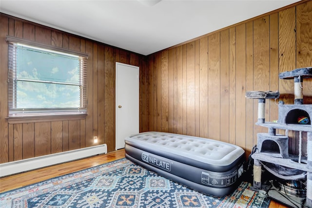 sitting room featuring hardwood / wood-style floors, wooden walls, and baseboard heating