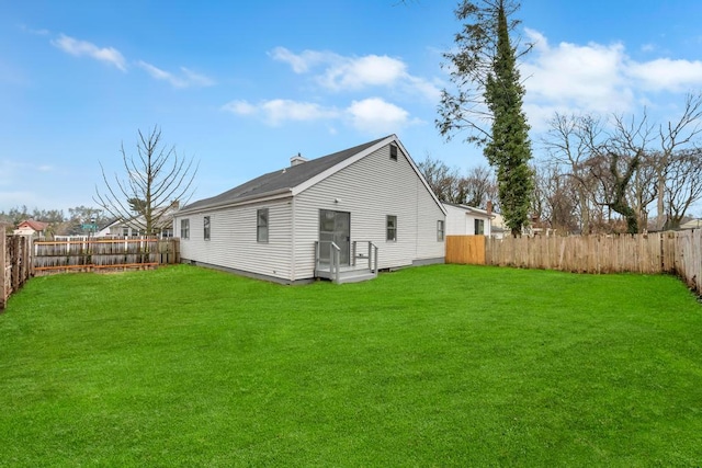 rear view of property featuring a lawn