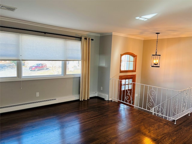 unfurnished room featuring dark wood-type flooring, a baseboard heating unit, crown molding, and a notable chandelier