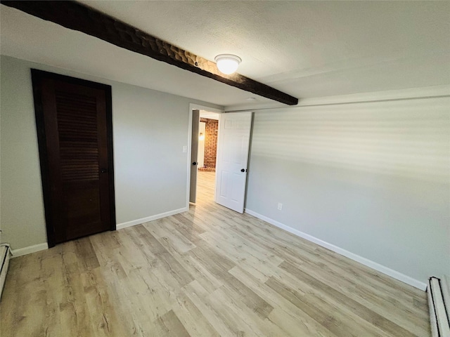 unfurnished bedroom with a baseboard radiator, a textured ceiling, beam ceiling, and light hardwood / wood-style floors