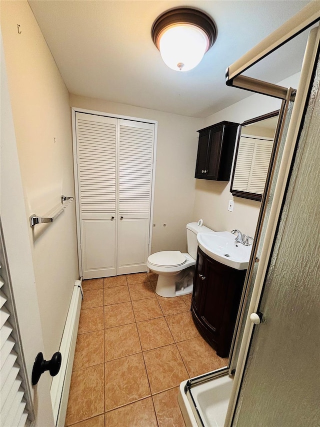 bathroom featuring a baseboard radiator, tile patterned flooring, vanity, toilet, and a shower with door