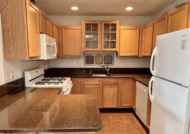 kitchen with sink, white appliances, and kitchen peninsula