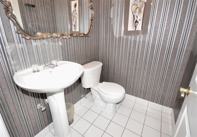 bathroom featuring sink, toilet, and tile patterned flooring