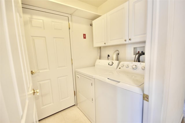 clothes washing area with cabinets, separate washer and dryer, and light tile patterned floors